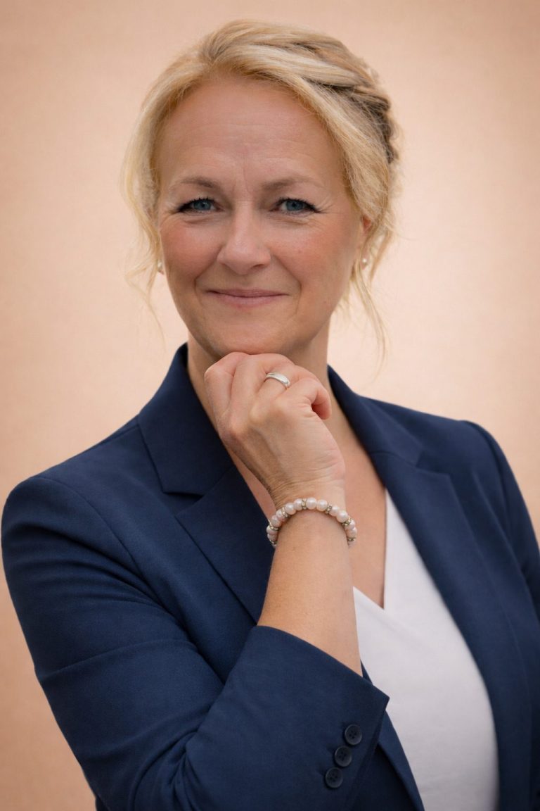 Natascha Kröhne Virtuelle Assistenz Blonde Frau blauer Blazer weiße Bluse rechte Hand am Kinne