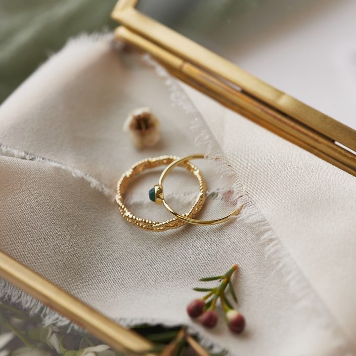 Traurednerin für freie Hochzeitszeremonien zwei goldene Ringe auf Stoff